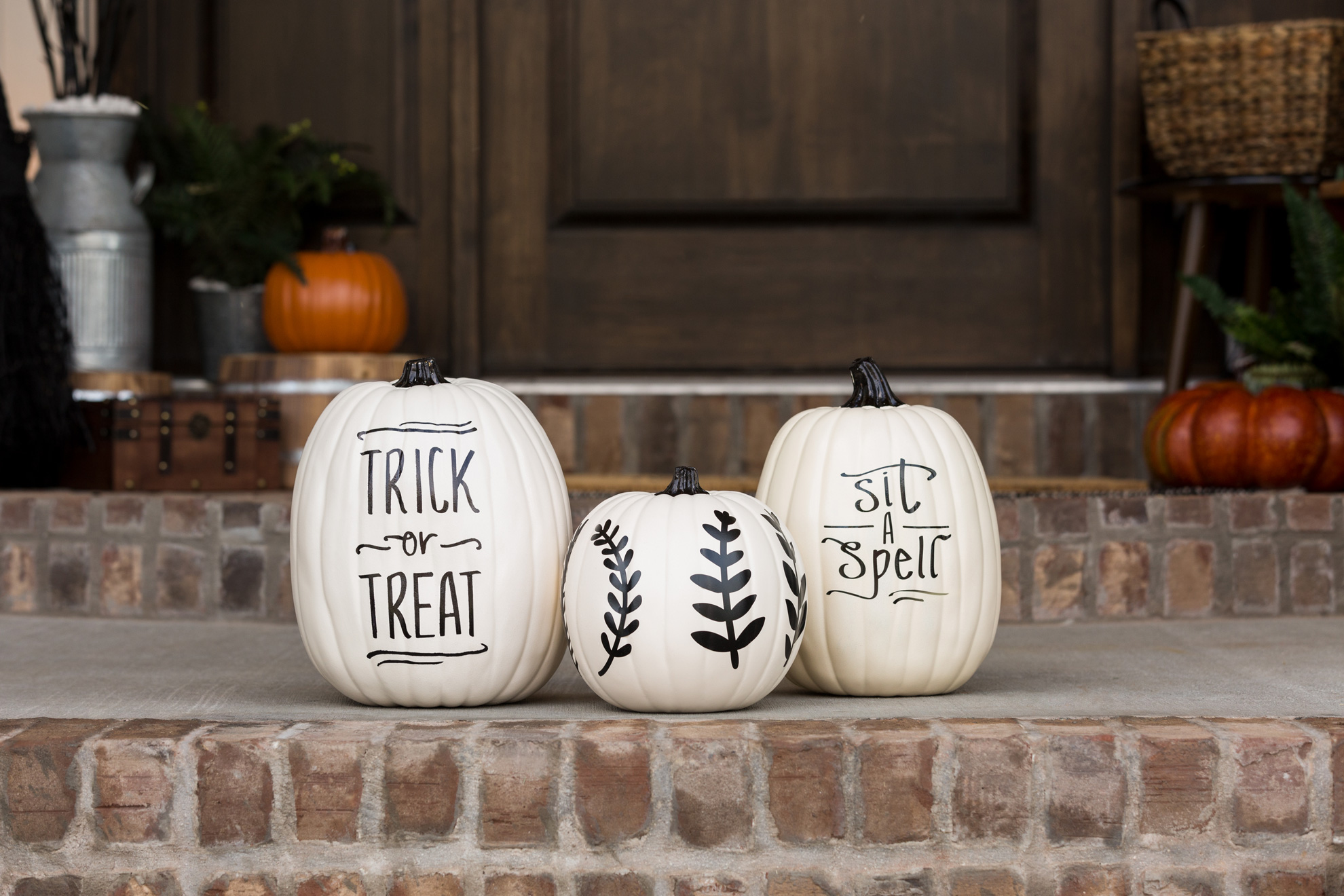 Decorated pumpkins sitting on an outdoor step