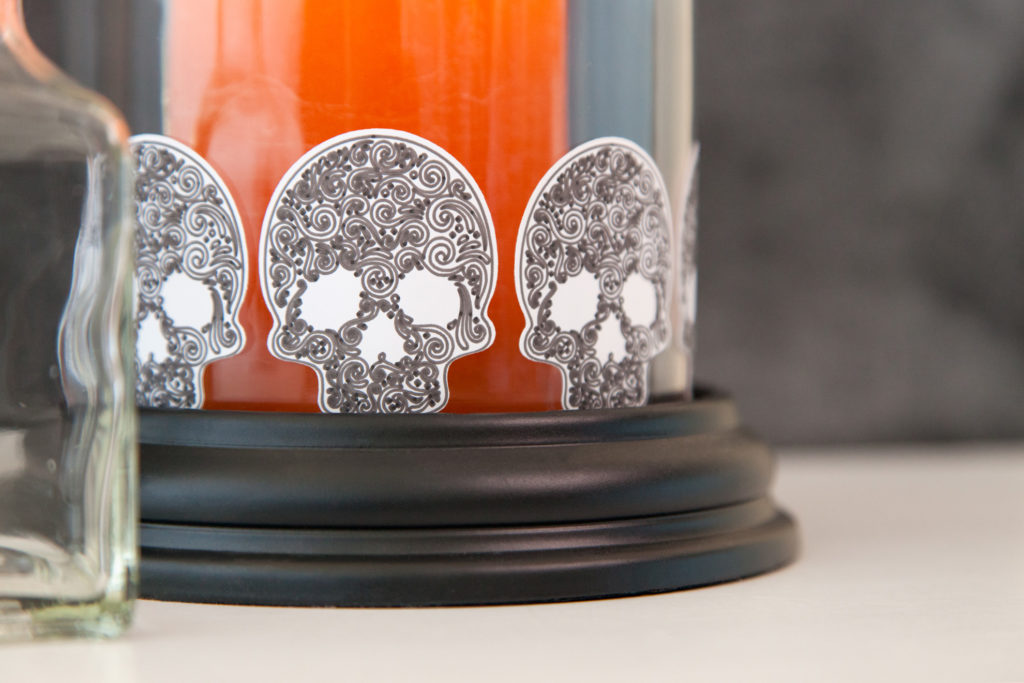 Orange Halloween candle in jar decorated with skull stickers