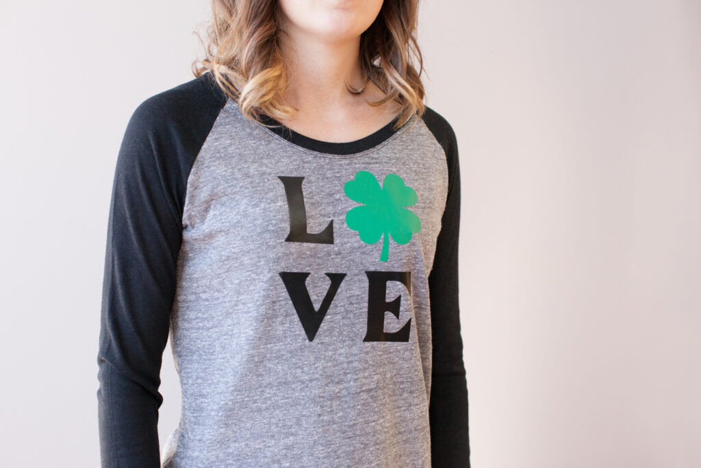 Baseball shirt made with Cricut that says Love with a four-leaf clover replacing the O