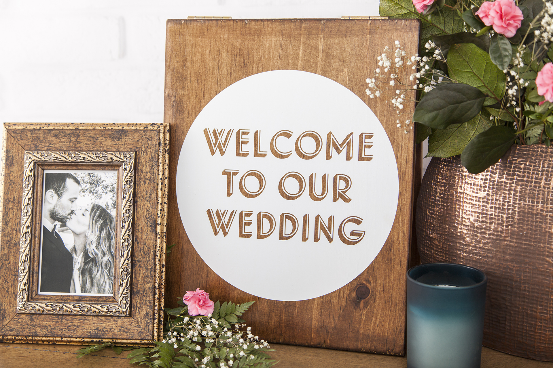 Panneau en bois indiquant « Bienvenue à notre mariage » en anglais à l'intérieur d'un cercle blanc