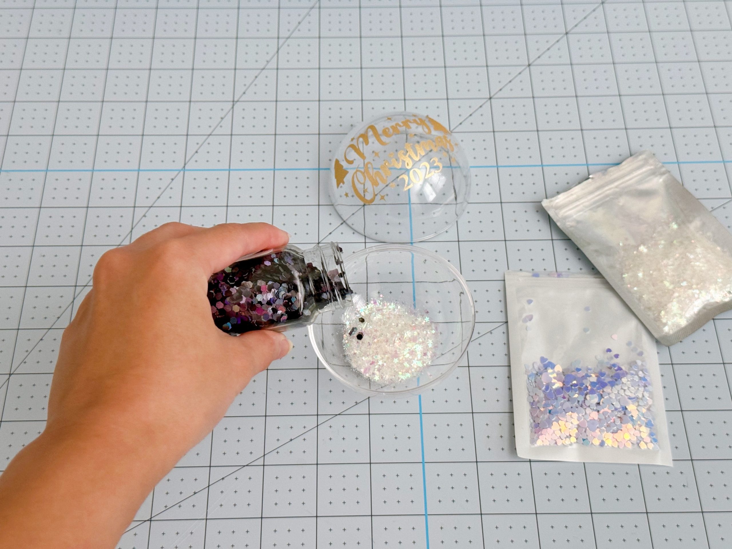 Decorating inside of clear acrylic ornament with assorted glitter