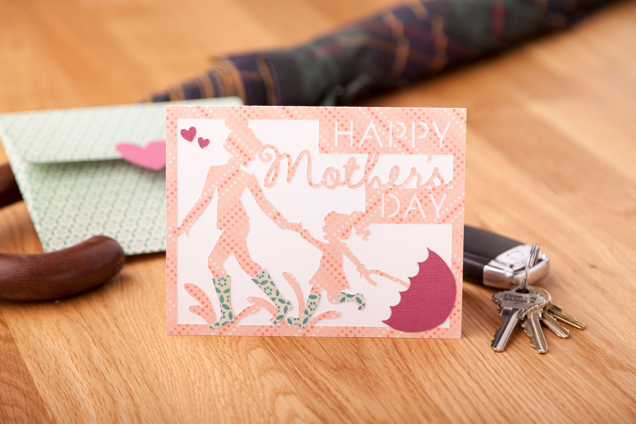 Mother's Day card with mom and child running through puddles 