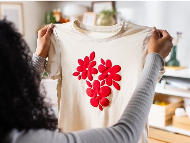 Woman's hand holding a smart phone with a personalized project template pulled up using Cricut's Design Space app