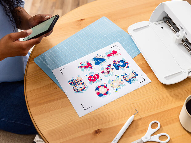 Woman's hand holding a smart phone with a personalized project template pulled up using Cricut's Design Space app