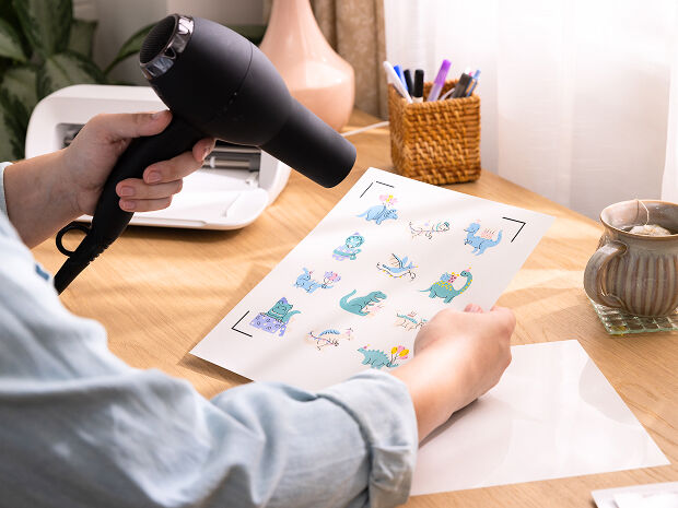 Woman's hand holding a smart phone with a personalized project template pulled up using Cricut's Design Space app