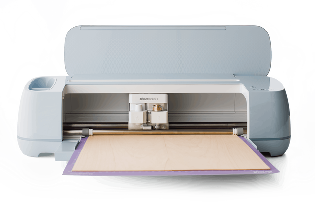 Cricut Maker 3 with basswood inserted on a cutting mat.