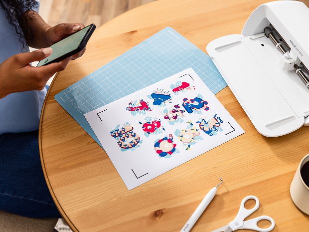 Woman's hand holding a smart phone with a personalized project template pulled up using Cricut's Design Space app