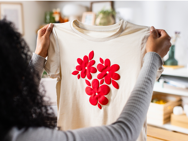 Woman's hand holding a smart phone with a personalized project template pulled up using Cricut's Design Space app
