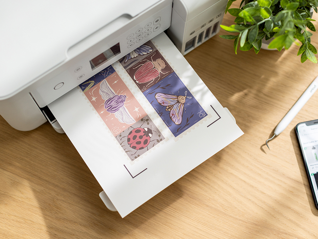 Woman's hand holding a smart phone with a personalized project template pulled up using Cricut's Design Space app